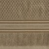 Beżowy ręcznik o wymiarach 50 x 90 cm z widocznym wzorem w postaci wypukłych kwadratów oraz poziomych pasów. Na zdjęciu nie ma widocznego tekstu ani logo producenta.