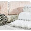 Beżowy dywanik łazienkowy o wymiarach 50 x 70 cm z widoczną teksturą i wzorem w postaci prostokątnej ramki. W prawym górnym rogu znajduje się powiększenie fragmentu dywanika, ukazujące szczegóły materiału i antypoślizgowe elementy na spodzie.