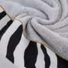 Srebrny ręcznik o wymiarach 50 x 90 cm z widocznym wzorem w czarno-białe pasy oraz brązowym obszyciem. Materiał ręcznika jest miękki i puszysty, co widać na zbliżeniu.