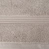 Beżowy ręcznik o fakturze frotte z widocznym poziomym pasem ozdobnym, składającym się z kilku cienkich, równoległych linii. Produkt ma wymiary 50 x 90 cm.