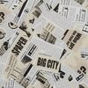 Zdjęcie przedstawia wzór pościeli z motywem gazetowym, na którym widoczne są fragmenty tekstów i grafik, takie jak "BIG CITY", "SPAPER", "Lorem ipsum" oraz ilustracje budynków. Tło jest beżowe, a teksty i grafiki są w kolorze czarnym.