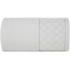 Biały ręcznik o wymiarach 50 x 90 cm, z delikatnym wzorem geometrycznym na jednym z końców. Materiał wygląda na miękki i puszysty, a wzór składa się z subtelnych, przecinających się linii tworzących romby.