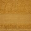 Musztardowy ręcznik o wymiarach 50 x 90 cm z widoczną teksturą frotte. Na środku znajduje się szeroki pas o delikatnie innej fakturze, dodający elegancji.