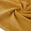 Zdjęcie przedstawia musztardowy ręcznik o wymiarach 70 x 140 cm, ułożony w sposób tworzący spiralny wzór. Materiał ręcznika jest puszysty i ma wyraźną fakturę, z widocznymi pasami wzdłuż krawędzi.