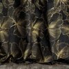 Czarno-złota zasłona z dużym, złotym wzorem kwiatowym na ciemnym tle. Materiał układa się w miękkie fałdy, podkreślając elegancki design.