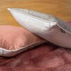 Na zdjęciu widoczne są dwie poduszki z poszewkami w odcieniach różowym i szarym, leżące na bordowym materiale. Poszewka EUROFIRANY Velvet 45 x 45 cm Ciemnomiętowy nie jest bezpośrednio widoczna.
