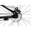 Zbliżenie na mechanizm tylnego koła roweru górskiego, ukazujące szprychy, piastę oraz łańcuch. Elementy te są wykonane z metalu i mają czarny kolor, a tło jest jasne.