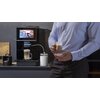 Czarny ekspres do kawy z dotykowym ekranem, na którym widoczne są ikony różnych rodzajów kaw: Cappuccino, Hot Water, Latte Macchiato, Espresso, Americano. Pod ekranem znajduje się logo "cecotec", a z boku ekspresu podłączony jest przezroczysty pojemnik z 
