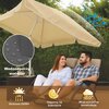 Beżowy parasol ogrodowy o średnicy 200 cm z widocznymi cechami: wodoodporny materiał, ochrona UV50+, odporny na blaknięcie, wiatroszczelna konstrukcja. Na zdjęciu widoczny jest również fragment mebli ogrodowych oraz zielone tło roślinne.
