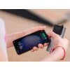 Na zdjęciu widać ręce trzymające smartfon oraz szary powerbank z wyświetlaczem. Na ekranie smartfona widoczna jest godzina 18:51 oraz informacja o ładowaniu baterii na poziomie 48%.