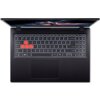 Na zdjęciu widoczny jest otwarty laptop z podświetlaną klawiaturą, na której klawisze W, A, S, D są wyróżnione czerwonym kolorem. Ekran laptopa wyświetla krajobraz z zachodem słońca.