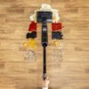 Na zdjęciu widoczny jest odkurzacz TEFAL X-Clean 7 GF5736F4 na drewnianej podłodze, zbierający różne rozlane substancje, takie jak płatki, sosy, jajko, sierść i inne zanieczyszczenia. Na odkurzaczu znajduje się logo "Tefal".