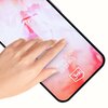 Na zdjęciu widać dłoń dotykającą ekran smartfona, na którym znajduje się tekst "Google Pixel 10/10 Pro" oraz logo "3mk". Tło ekranu jest w odcieniach różu i bieli.