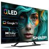 Na zdjęciu widoczny jest telewizor z ekranem wyświetlającym grafikę przedstawiającą twarz z zielonymi i pomarańczowymi akcentami oraz teksty: "QLED", "Google TV", "Dolby Vision Atmos" i "SHARP". Telewizor ma nowoczesny design z cienką ramką i stoi na pros