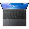 Na zdjęciu widoczny jest otwarty laptop z klawiaturą QWERTY i dużym touchpadem, a na obudowie nad klawiaturą znajduje się logo "CHUWI". Ekran laptopa wyświetla abstrakcyjny wzór w odcieniach niebieskiego i białego.