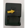 Czarny ładowarka do baterii z napisem "Nikon BATTERY CHARGER MH-32" oraz wskaźnikami "CHARGE" i "END". Na ładowarce znajduje się żółta strzałka wskazująca na tekst.