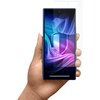 Na zdjęciu widoczny jest smartfon trzymany w dłoni, z nałożoną folią ochronną na ekranie. Ekran telefonu wyświetla kolorowy, abstrakcyjny wzór z dominującymi odcieniami fioletu i niebieskiego.