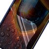 Zdjęcie przedstawia telefon z nałożoną folią ochronną, która jest częściowo odklejona, ukazując ekran. Na ekranie widoczne są krople wody oraz abstrakcyjne wzory w intensywnych kolorach.