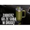 Zielony kubek termiczny o pojemności 1200 ml umieszczony jest w uchwycie samochodowym, a obok niego widoczny jest napis: "ZABIERZ GO ZE SOBĄ W DROGĘ!".