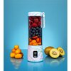 Na zdjęciu znajduje się blender personalny z kolorowym, marmurkowym wzorem, wypełniony owocami: malinami, jagodami, kawałkami pomarańczy i mango. Obok blendera leżą kumkwaty oraz przekrojone na pół kiwi, a na obudowie blendera widnieje napis "BlendyGo".