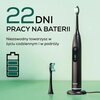 Na zdjęciu widoczna jest szczoteczka soniczna w kolorze granatowym z wyświetlaczem pokazującym 80% naładowania, stojąca na podstawce, obok której znajduje się dodatkowa końcówka. W tle znajduje się tekst: "22 dni pracy na baterii. Niezawodny towarzysz w ż