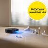 Czarny robot sprzątający porusza się po podłodze, emitując niebieskie światło, które omija przeszkody takie jak kabel, kapcie i pudełko. W prawym górnym rogu znajduje się żółte koło z napisem "PRECYZYJNA NAWIGACJA LDS".