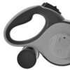 Na zdjęciu widoczna jest szara smycz z ergonomicznym uchwytem i pojemnikiem na worki, z wyraźnym przyciskiem na obudowie. Produkt ma gładką powierzchnię z delikatnymi wypustkami dla lepszego chwytu.