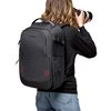 Czarny plecak Manfrotto Pro Light II Frontloader M jest noszony przez osobę trzymającą aparat fotograficzny z dużym obiektywem. Plecak ma teksturowaną powierzchnię, widoczne czerwone akcenty i logo "Manfrotto" na górnej części.