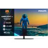 Na zdjęciu widoczny jest telewizor z logo "PHILIPS" w prawym górnym rogu, a po lewej stronie znajduje się panel z tekstem: "AMBILIGHT tv MAIN PARTNER OF FC BARCELONA", oraz ikonami i napisami: "OLED", "4K UltraHD", "AI Intelligent Picture Engine", "Dolby 