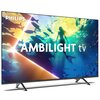 Telewizor z wyświetlaczem pokazującym kolorową scenę podwodną z sylwetką syreny i rybami, z widocznym tekstem "PHILIPS" oraz "AMBILIGHT tv". Urządzenie stoi na dwóch metalowych nóżkach.