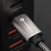 Srebrny kabel USB-C jest podłączony do urządzenia, które znajduje się na czarnym tle o fakturze skóry. Na wtyczce kabla widoczne jest logo "FORCELL".