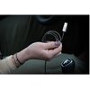 Na zdjęciu widać rękę trzymającą srebrny kabel USB-Lightning o metalicznym oplocie, z końcówką Lightning skierowaną do góry. W tle znajduje się wnętrze samochodu, widoczna jest kierownica oraz dźwignia zmiany biegów.
