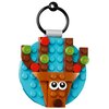Ozdoba świąteczna z klocków LEGO przedstawia renifera na tle okrągłej, niebieskiej płytki. Klocki mają różne kolory, w tym brązowy, czerwony i zielony, a na niektórych z nich widnieje napis "LEGO".