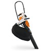 Odkurzacz akumulatorowy w kolorze białym i pomarańczowym z czarnym workiem na odpady. Na urządzeniu widoczne jest logo "STIHL".