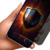 Na zdjęciu widoczna jest dłoń trzymająca smartfon z nałożoną folią ochronną, na ekranie której znajduje się grafika przedstawiająca tarczę z okiem w środku, otoczoną dynamicznymi, świetlnymi efektami. Folia ma matowe wykończenie i funkcję prywatności, co 