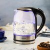 Czajnik elektryczny z przezroczystym korpusem i czarnymi elementami, z widoczną miarką pojemności do 1,7 litra. Obok znajduje się pudełko z napisem "klausberg ELECTRIC KETTLE" oraz oznaczeniem modelu "KB-7886".