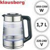 Na zdjęciu znajduje się szklany czajnik elektryczny z metalowymi i plastikowymi elementami, wypełniony wodą do poziomu oznaczonego jako "0,5L MIN". Na czajniku widoczne są wymiary: wysokość 23 cm, szerokość 21,5 cm oraz średnica podstawy 15 cm; logo "klau