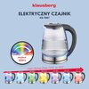 Na zdjęciu znajduje się czajnik elektryczny z przezroczystym korpusem i czarną rączką, umieszczony na tle z tekstem. Widoczne napisy to: "klausberg", "CZAJNIK ELEKTRYCZNY KB-7887", "CO ZWIĘKSZA BEZPIECZEŃSTWO UŻYTKOWANIA CZAJNIKA ELEKTRYCZNEGO?", "AUTOMAT