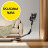 Na zdjęciu znajduje się odkurzacz z elastyczną rurą, który odkurza podłogę pod sofą. W lewym górnym rogu widoczny jest żółty okrąg z czarnym napisem "SKŁADANA RURA".