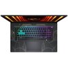 Na zdjęciu widoczny jest otwarty laptop z podświetlaną klawiaturą w różnych kolorach, w tym zielonym, niebieskim i fioletowym. Na obudowie laptopa znajdują się wzory przypominające linie i kształty geometryczne, a na ekranie widoczny jest pomarańczowy wzó