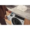 Pralka ELECTROLUX UltraCare 800 EW8F3614QP z otwartą szufladą na detergenty, do której wkładana jest kapsułka. Na blacie nad pralką leży stos złożonych białych ręczników.