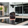 Na zdjęciu znajduje się butelka płynu do czyszczenia płyt ceramicznych FRISCHER Professional 1000 ml, ustawiona na płycie kuchennej. Na etykiecie widnieje napis: "FRISCHER Professional KOCHFELDREINIGER HOB CLEANER 1L".