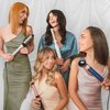 Na zdjęciu widoczne są cztery kobiety trzymające różne modele suszarko-lokówek. W tle znajduje się biała, drapowana tkanina.