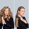 Na zdjęciu widoczny jest produkt "Suszarko-lokówka DYSON Airwrap Co-anda 2x Straight+Wavy Pastelowy róż 1700 W" używany do stylizacji włosów. Po lewej stronie urządzenie tworzy loki, a po prawej prostuje włosy.