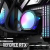 Na zdjęciu znajduje się element chłodzenia wodnego z podświetleniem RGB, na którym widoczny jest napis "TCOMAS". W tle widać fragmenty innych komponentów komputerowych, w tym napis "GEFORCE RTX" oraz "DOMINATOR".