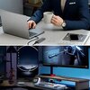 Na zdjęciu widoczny jest laptop z podłączoną obudową dysku, obok której leży filiżanka oraz czasopismo z telefonem na okładce z napisem "CREA". W dolnej części zdjęcia znajduje się biurko z dwoma monitorami, klawiaturą, zegarem elektronicznym pokazującym 
