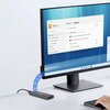 Na zdjęciu znajduje się monitor komputerowy z wyświetlonym oknem ustawień systemowych, gdzie widoczny jest tekst: "System > Display" oraz lista opcji takich jak "Display orientation" i "Multiple displays". Obok monitora leży obudowa dysku z logo "ZENWIRE"