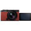 Czerwony aparat bezlusterkowy z obiektywem, na którym widnieje napis "LUMIX" oraz oznaczenia "5.4-5.6/18-40mm". Obok aparatu znajduje się odchylany ekran LCD.