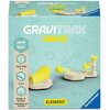 Na zdjęciu znajduje się pudełko gry logicznej "Gravitrax Junior Dodatek Skoczek" od Ravensburger, z grafiką przedstawiającą elementy gry w kolorach żółtym i białym. Na opakowaniu widnieją napisy: "GRAVITRAX JUNIOR", "JUMP SAUT", "Age 3-7", "5 pc", "Made i