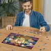 Na zdjęciu widać osobę układającą puzzle na okrągłym drewnianym stole, z widocznym fragmentem układanki przedstawiającej kolorowe planety i kosmiczne motywy. W tle znajduje się roślina doniczkowa oraz zasłony.